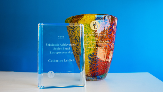 An award trophy and award vase on a table against a blue wall