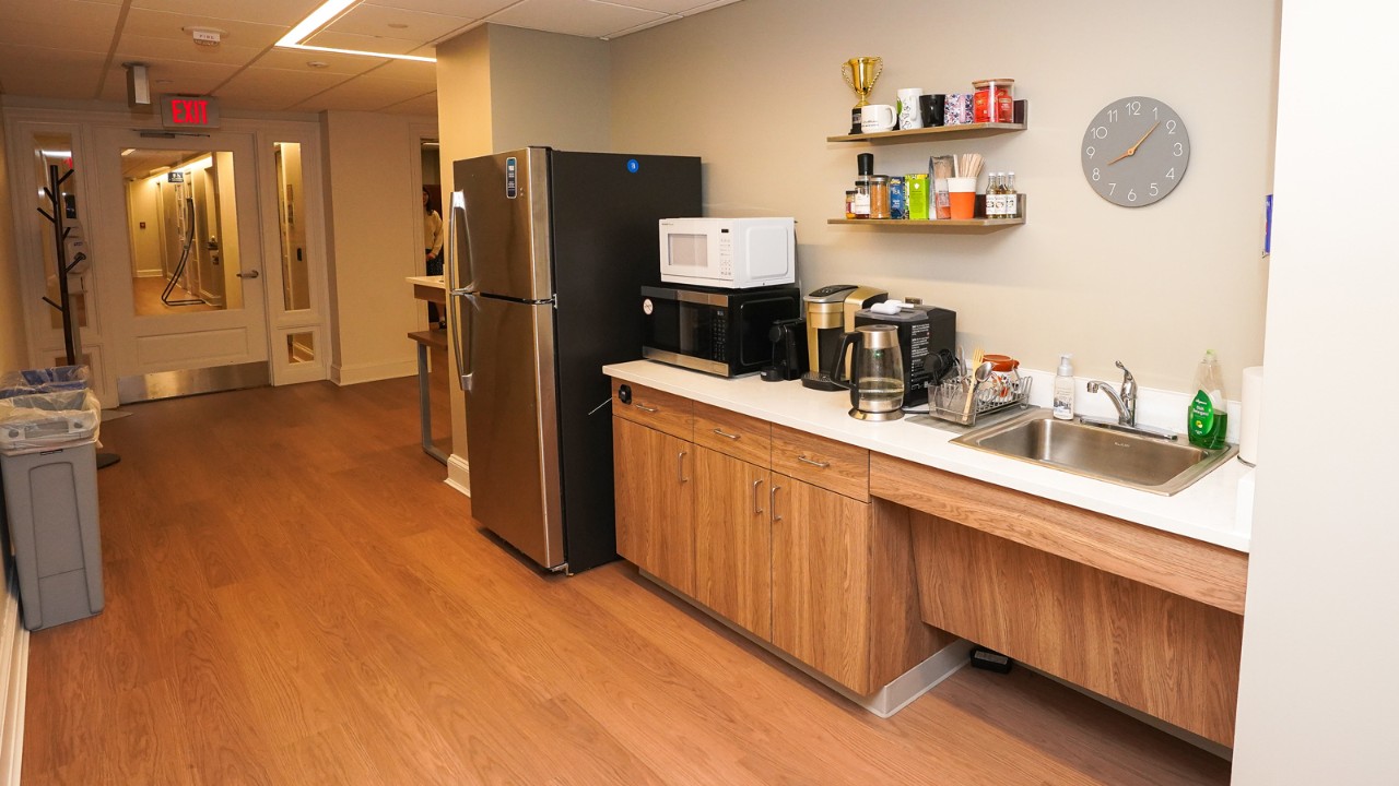 a kitchen with sink, counter space and a refrigerator against the far wall