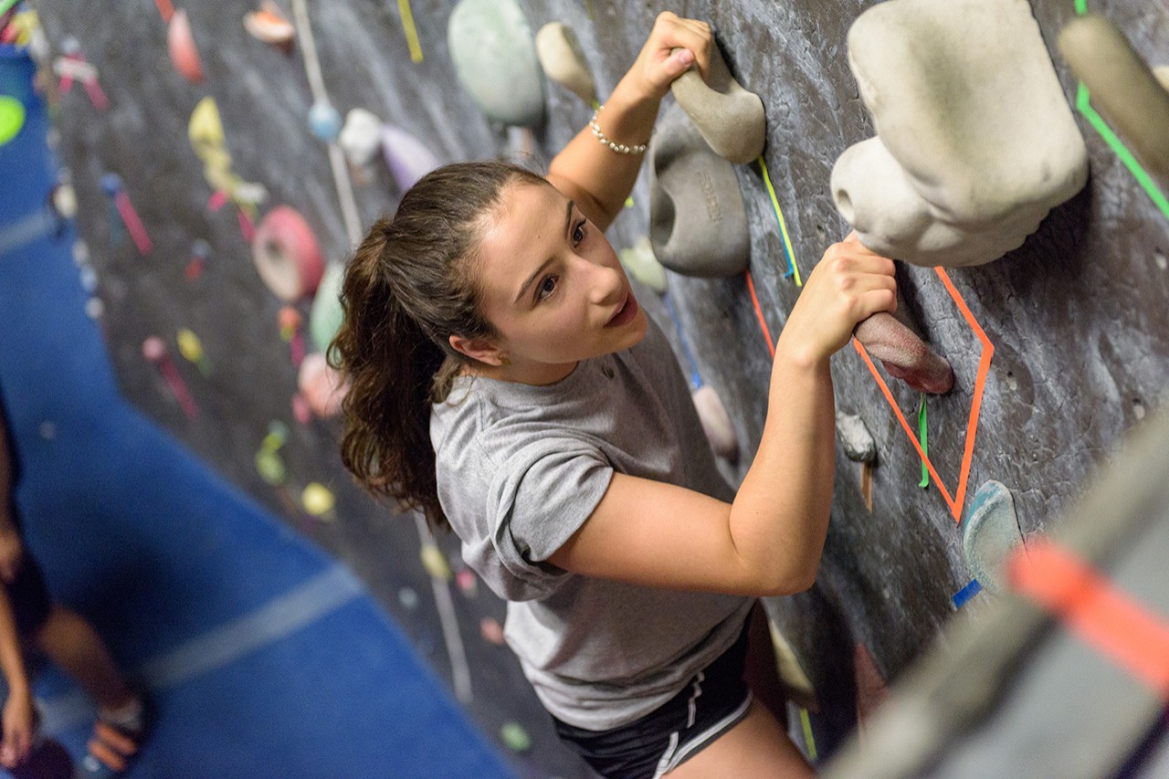 A student climbs a rock wall