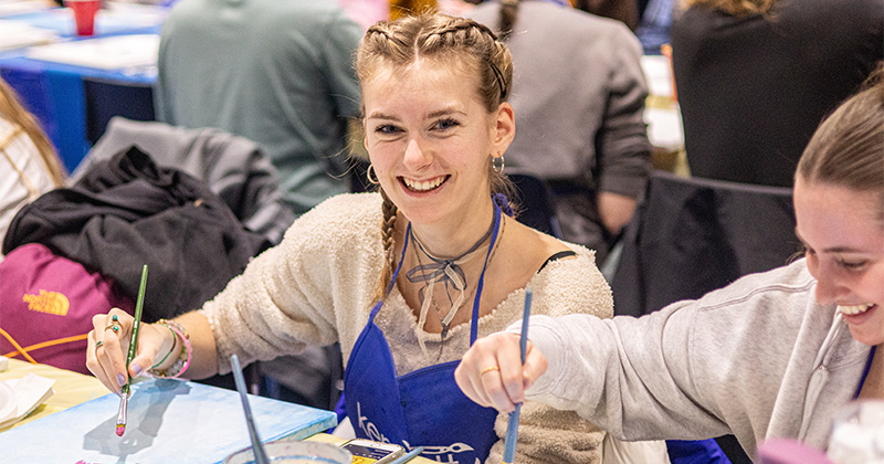 Two female students painting canvases