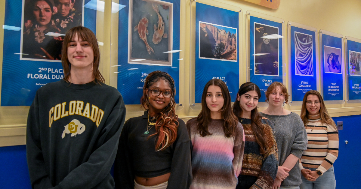 Art contest winners pose in front of the exhibition display