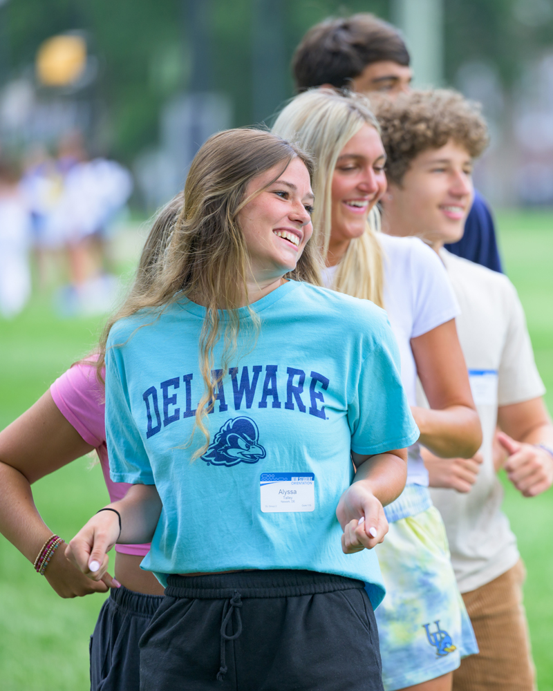 students in a line dance on The Green as part of their New Student Orientation tour