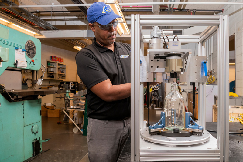 Derrick Allen works in the machine shop in the basement of Sharp Lab developing and building projects directly submitted by students and faculty alike, July 6th, 2020. Also: Derrick Allen does NOT have to wear a mask according to the guidelines from EHS since he is the only person in the machine shop with a large amount of square footage.  The photographer did wear a mask and kept the 6 foot social distancing during the entire assignment.
