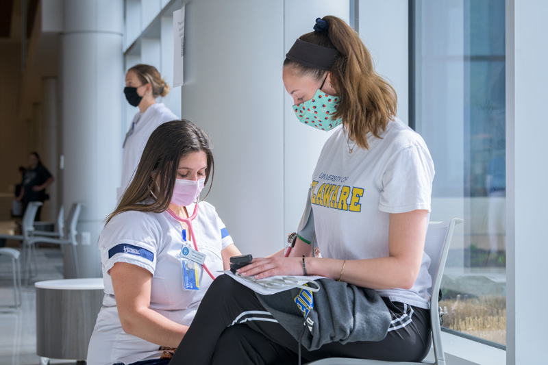 COVID-19 vaccination clinic held by Albertsons / Acme markets in the University of Delaware’s STAR Tower. Targeted specifically at specifically for employees and those affiliated with institutions of higher education in the state of Delaware.Pictured: After receiving her COVID-19 vaccination, Hannah Gentry (right), a Junior Biomedical Engineering major (Class of 2022) has her vitals checked by Julianna Giovan, a Senior Nursing Student (Class of 2021)