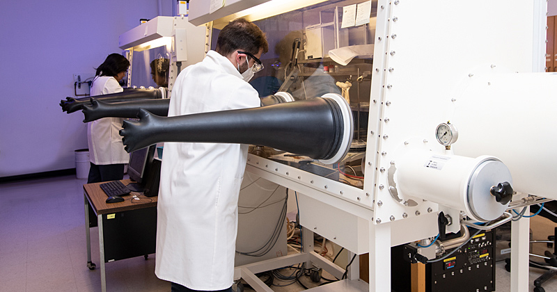 Perovskite thin films are a new high-performing photovoltaic material and a focus of IEC research. Here, Chai Santiwipharat (left) and Austin Kuba are processing these thin films using air-free gloveboxes.