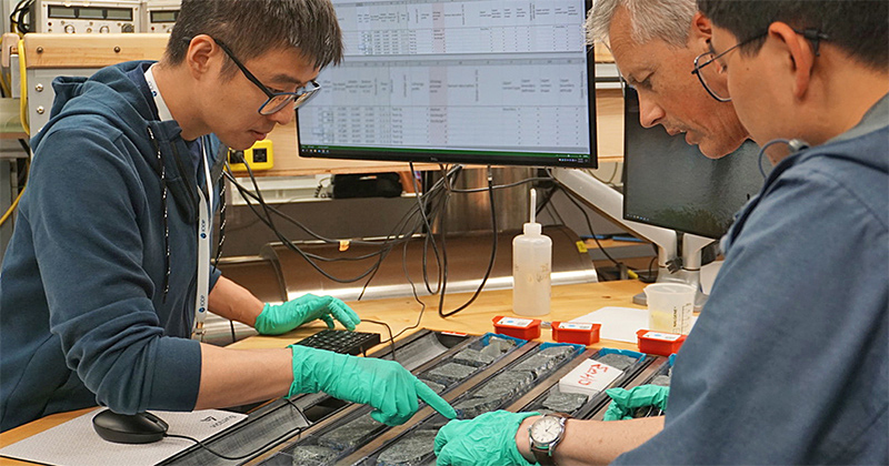 When the rocks were recovered from the seafloor, the first thing that Lin (on the left) and the rock description teams would do is create the scientific descriptions of the primary features of those rocks — defining what kind of rocks they were, what minerals they had, and the physical descriptions such as fabrics and texture. 