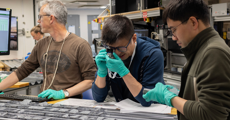 When the rocks were recovered from the seafloor, the first thing that Lin (center) and the rock description teams would do is create the scientific descriptions of the primary features of those rocks — defining what kind of rocks they were, what minerals they had, and the physical descriptions such as fabrics and texture.