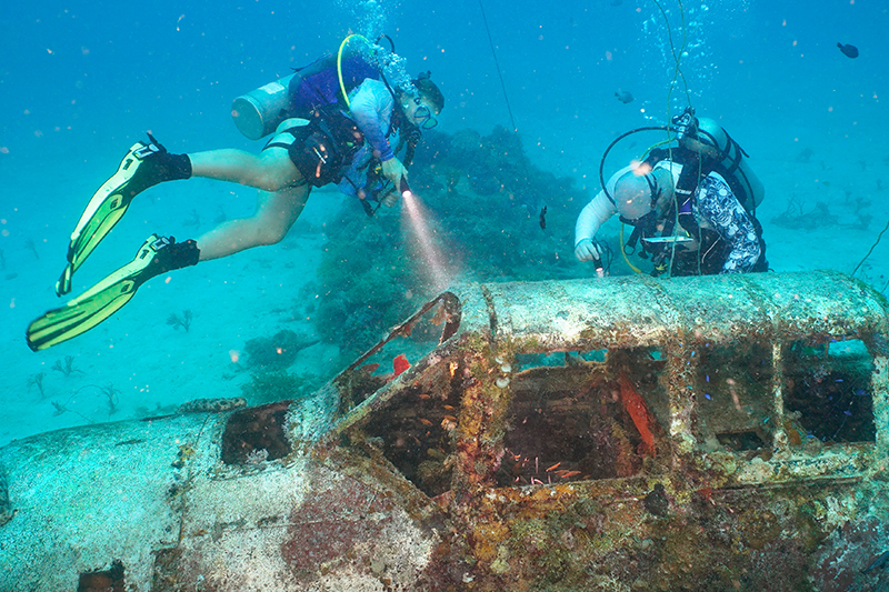 Evan McArdle, pictured (right), is spending part of his summer on a Study Abroad program to Micronesia with Project Recover, the nation’s foremost citizen-led, nonprofit organization to search, locate, document, recover and repatriate the more than 81,500 American service members missing in action. McArdle is pictured here with Sibyl Roosen (left), a UD student studying mechanical engineering, investigating a Nakajima B6N that was found on the Project Recover mission. 