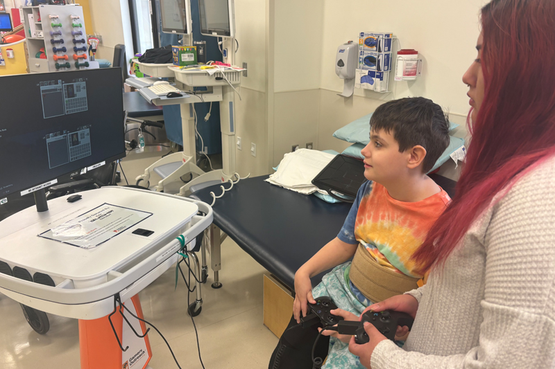 Cristhina Reyes plays an online game with a young patient at Nemours Children’s Hospital. These games help the kids learn and have fun outside of the normal hospital routine.