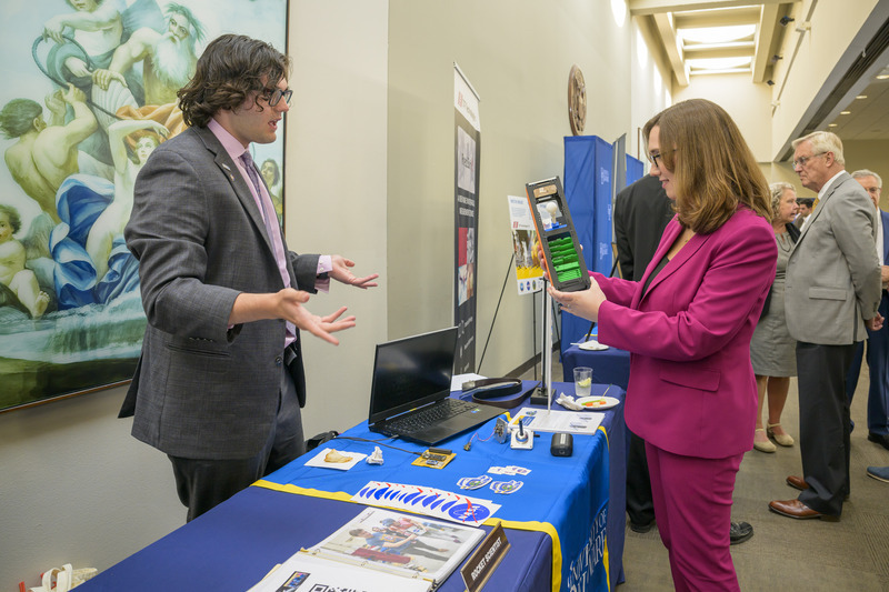 T.J. Tomaszewski, a senior physics major at the University of Delaware, talks to U.S. Rep. Sarah McBride about a Langmuir Probe, which researchers use to measure plasma in the atmosphere.