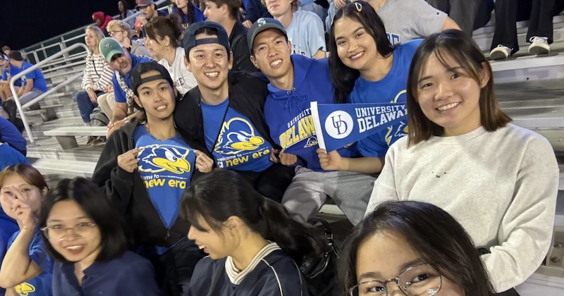 International students, including Fatema Mohammadi (top row, right), enjoy a UD football game after learning about the sport and what it’s like to be a UD football player at a Football 101 event, sponsored by UD Athletics. 