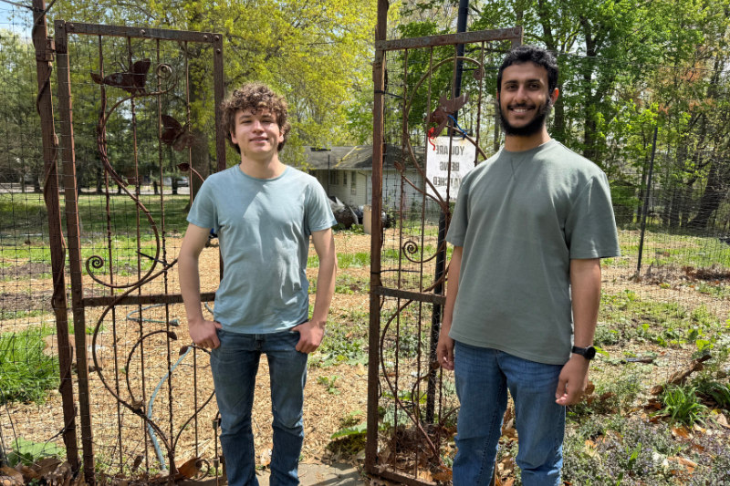 Bretzger (left) and Al Barwani in front of the garden in the spring, before most crops began to flourish.