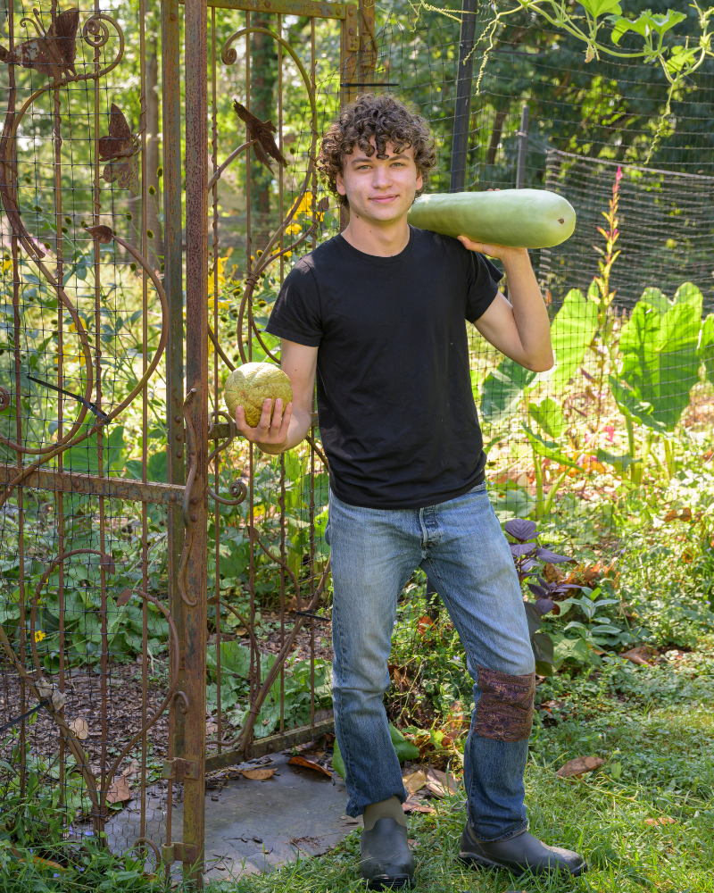 Bretzger shows off lauki bottle gourds grown in the garden. The bottle gourds come from Gujarat, India. When they are young, they are similar to a zucchini, but as they age the flesh hardens and they can be used as storage vessels. 