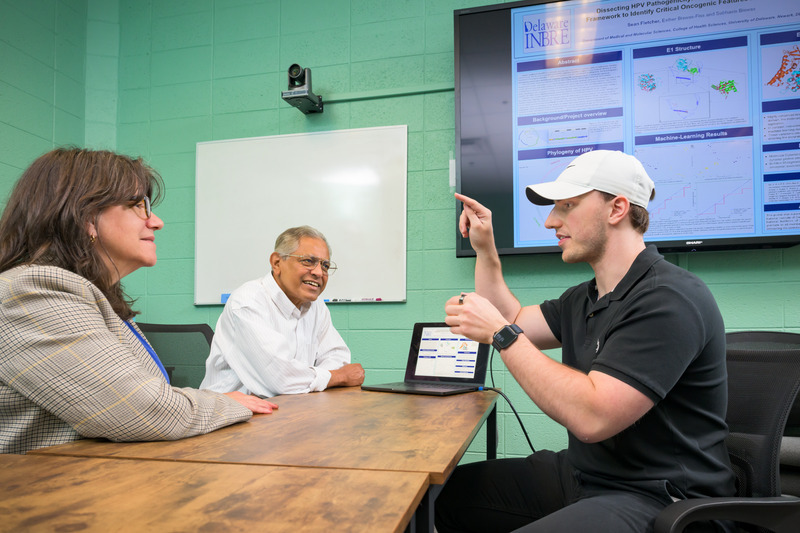 Sean Fletcher (right), an aspiring physician, talks about the role of bioinformatics in his research with mentors Esther Biswas-Fiss (left), professor and chair of the Department of Medical and Molecular Sciences, and Sam Biswas (center), professor of medical and molecular sciences.