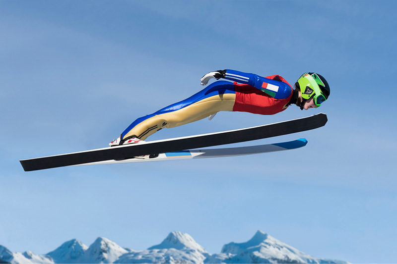 Ski jumpers combat the air resistance that shortens the distance they fly by leaning as close as possible to their skis. 