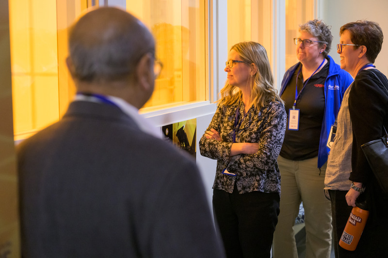 Members of the DuPont delegation peer into the Nanofabrication Laboratory in the Harker Interdisciplinary Science and Engineering Laboratory.