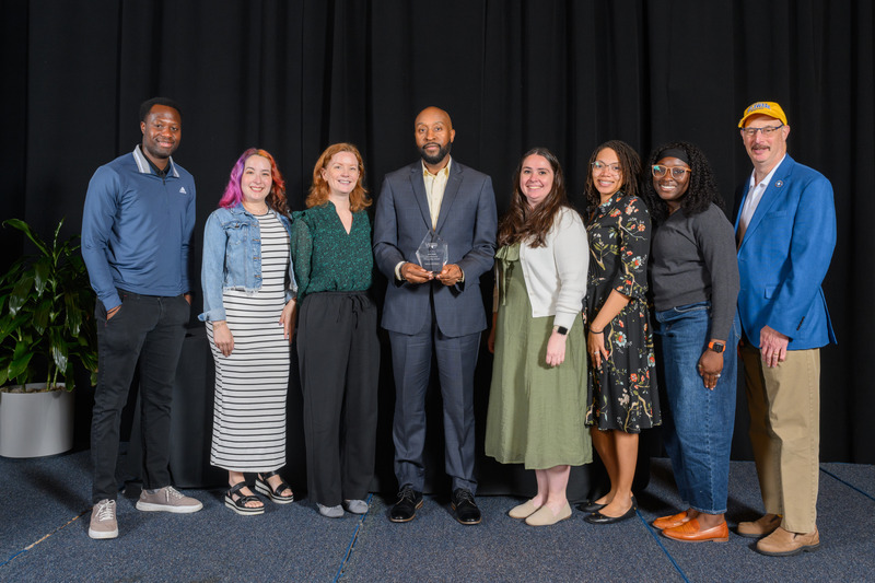 Excellence in Leadership Award winner, Adrian McCleary (center), with the University Studies and Student Support Programs team.