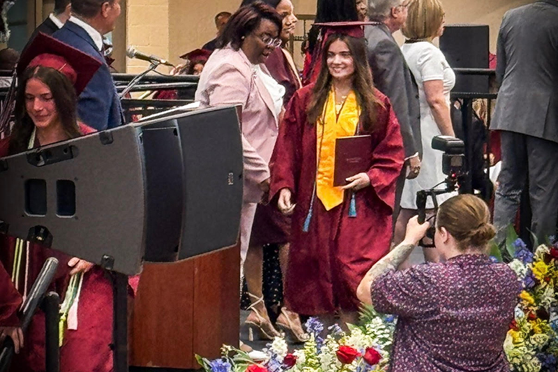 Peyton Harter walks across the stage after receiving her diploma at Appoquinimink High School in June 2025. 