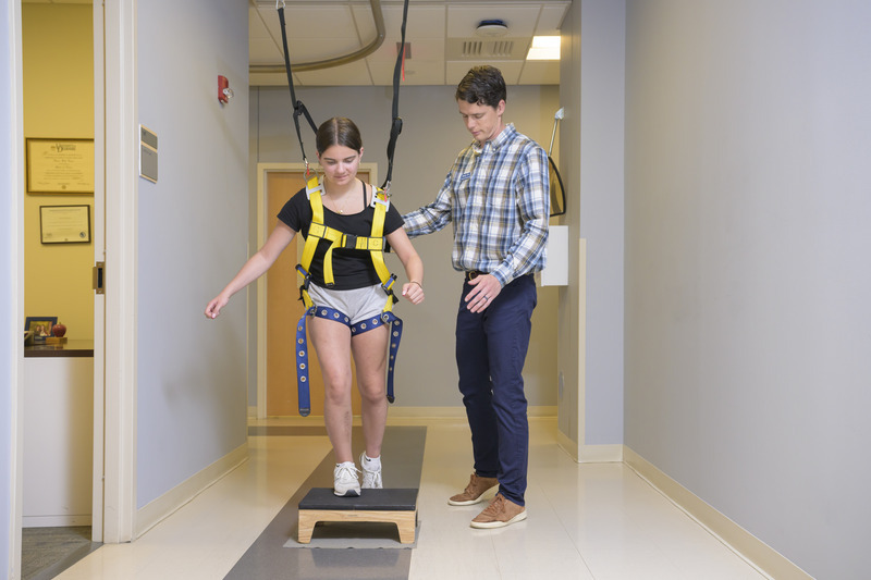 Peyton Harter (left) set a goal early on in her physical therapy: she wanted to walk unassisted across the stage at her high school graduation. With help from Jimmy Orr (right), a physical therapist in UD’s Physical Therapy Clinic, her dreams were realized. 